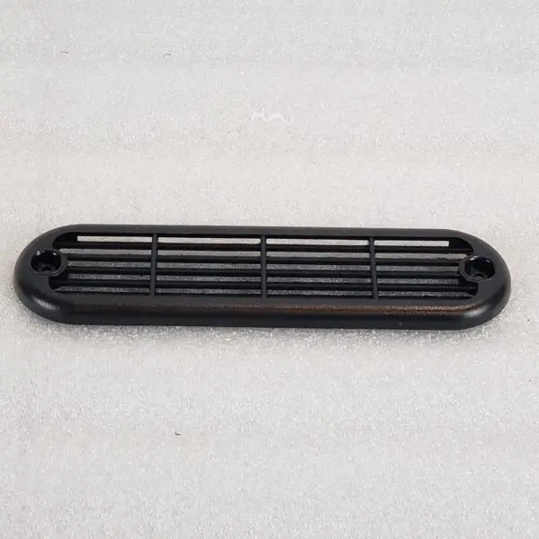 A black plastic air vent on top of a white surface.