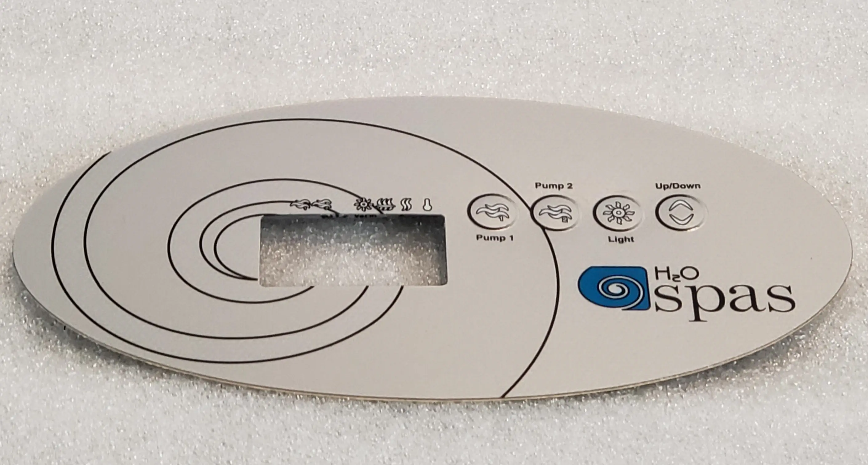 A white remote control sitting on top of a bed.