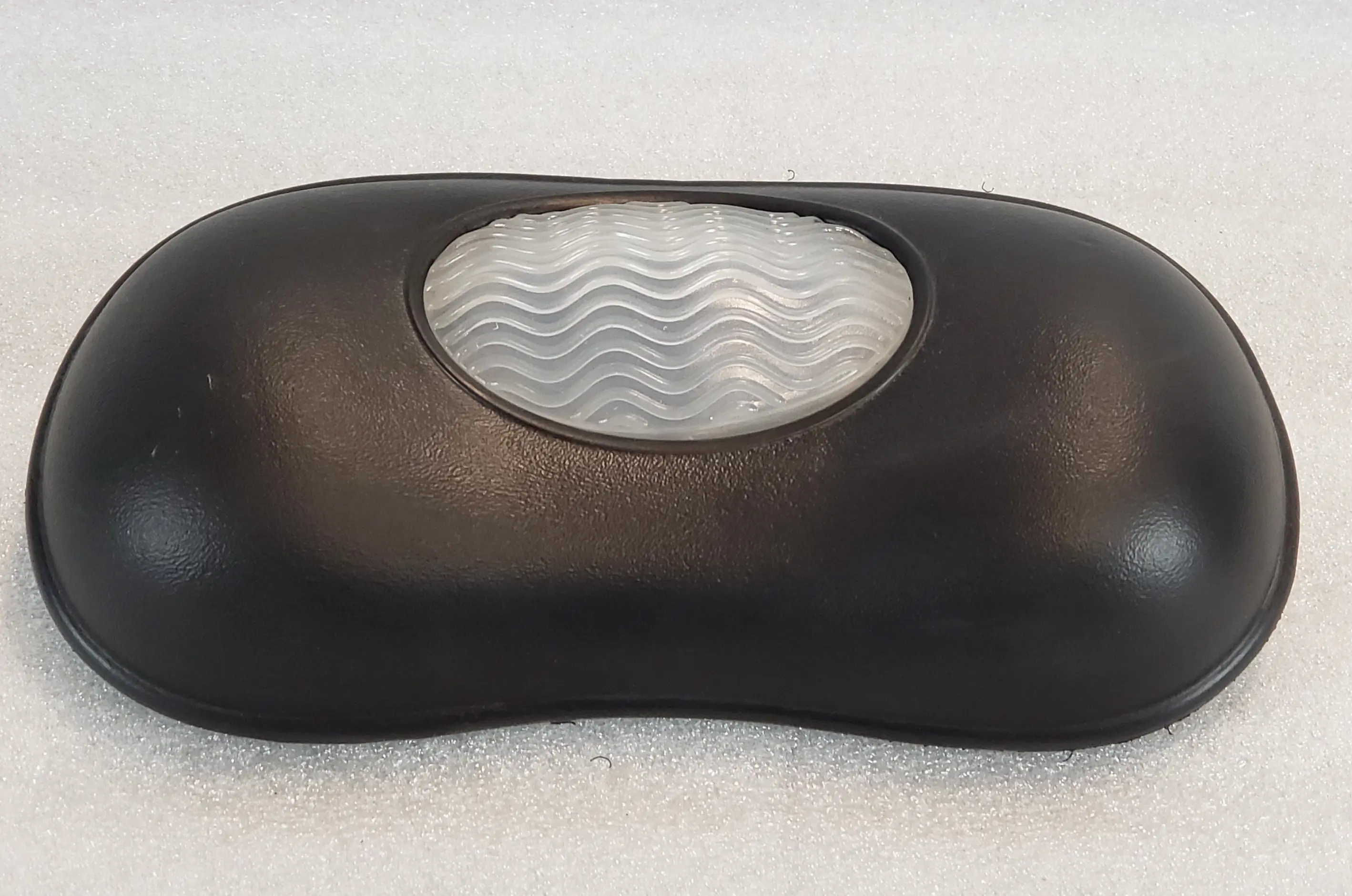 A black pillow with a white wave pattern on it.