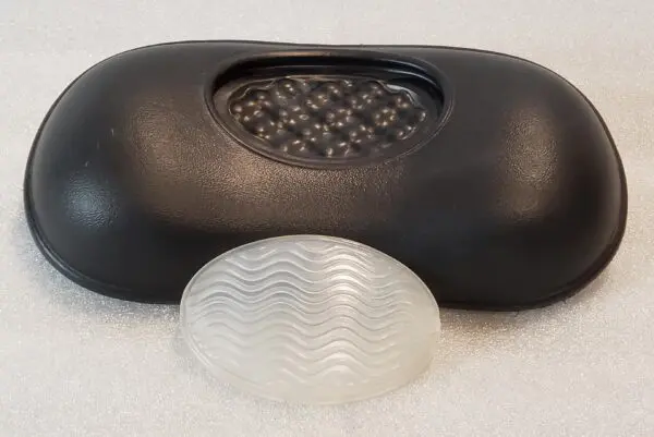 A black case and white plastic object on the ground.