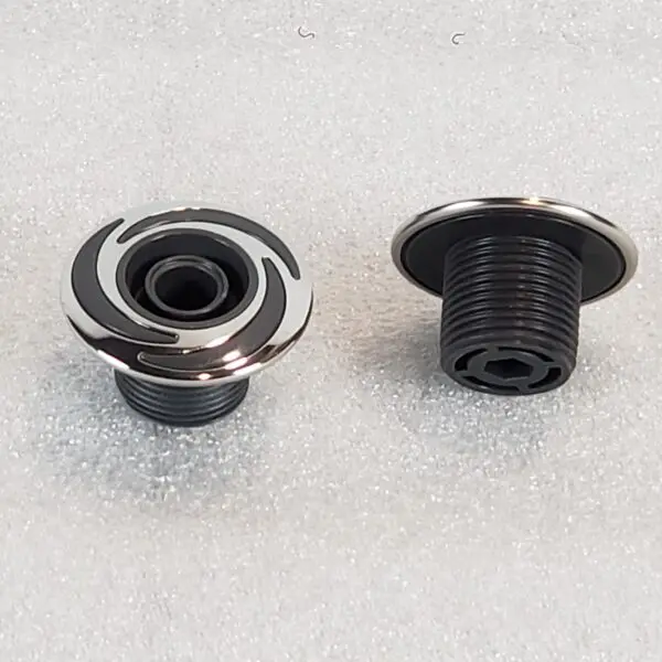 A pair of black and silver knobs on the floor.