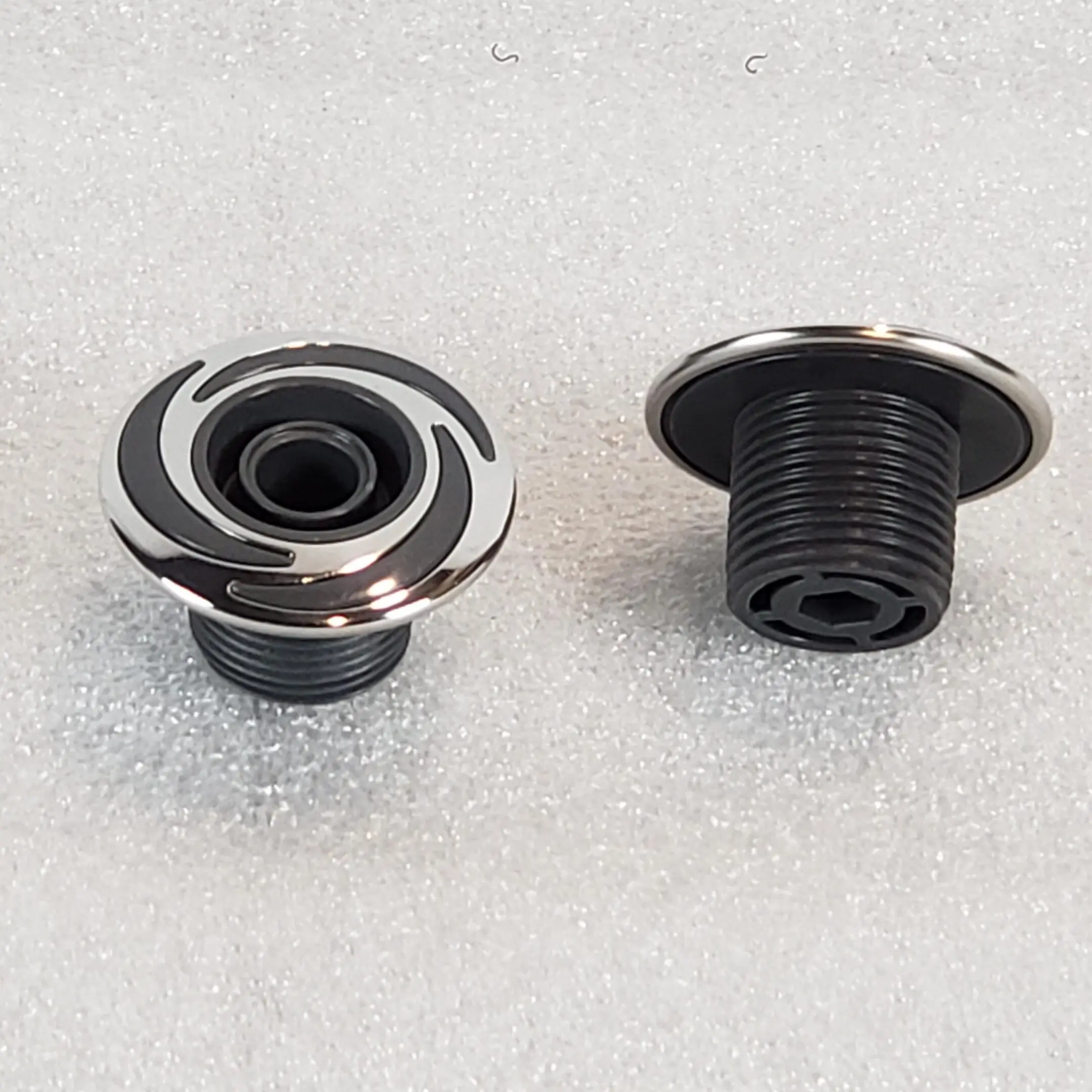 A pair of black and silver knobs on the floor.