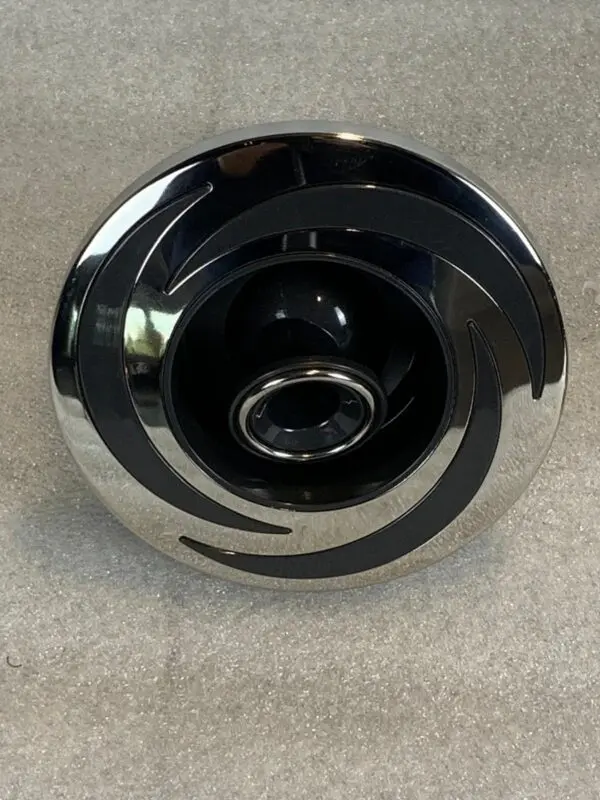 A chrome and black knob on the floor