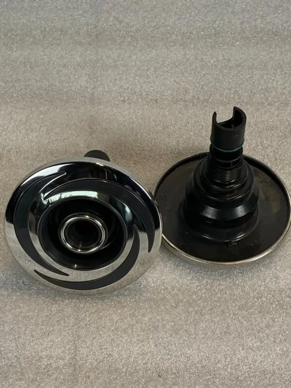 A pair of black and silver knobs on the side of a table.