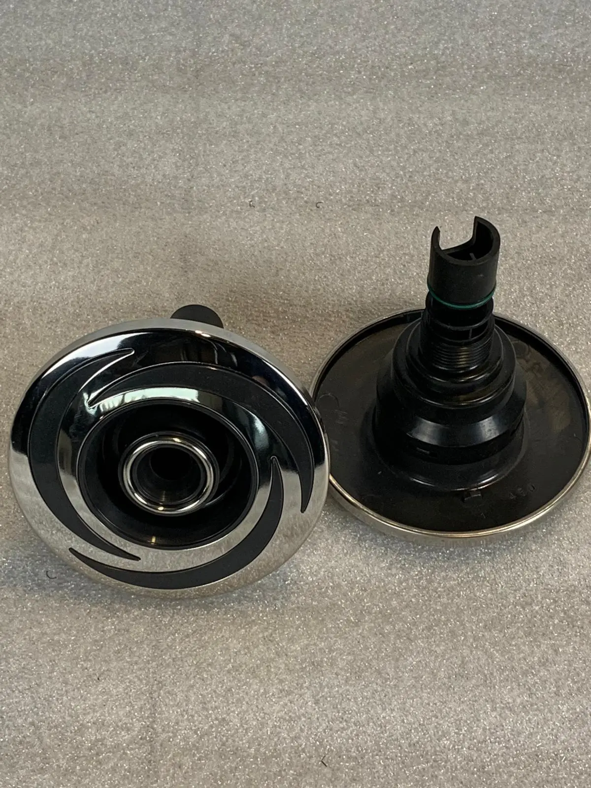 A pair of black and silver knobs on the side of a table.