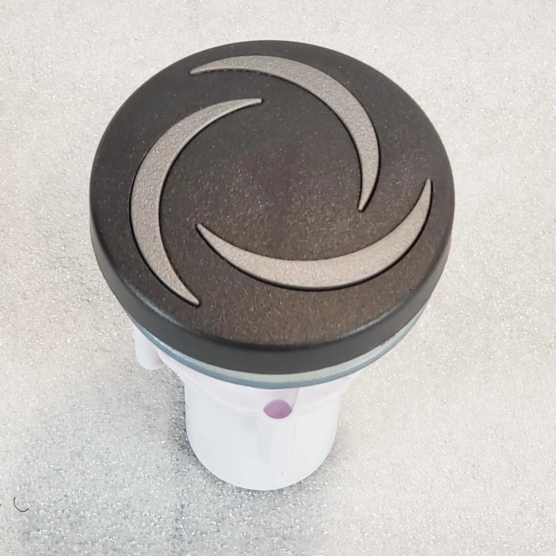 A white and black car cup holder with a swirl design.