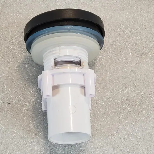 A white faucet with black cap on the floor.