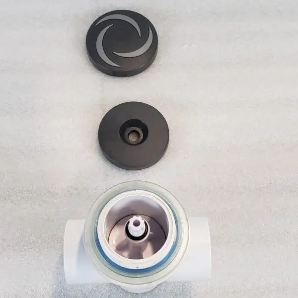 A white pipe sitting next to two black knobs.