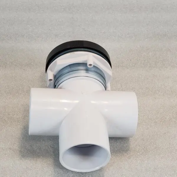 A white pipe with a black cap sitting on top of the floor.