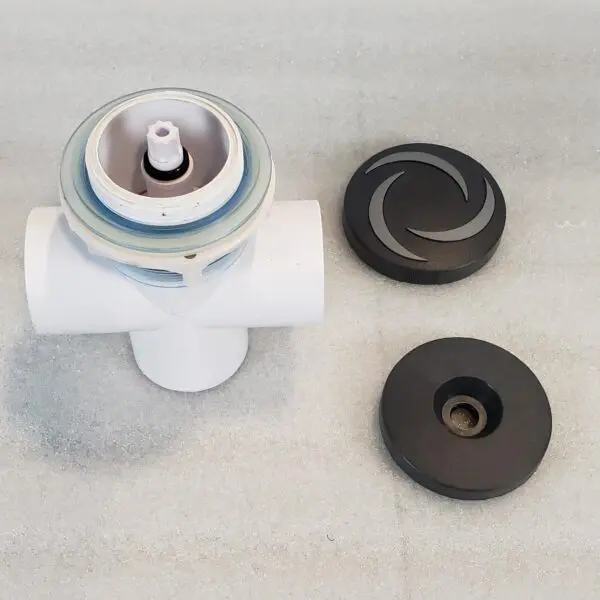A white toilet with two black knobs and one brown knob.