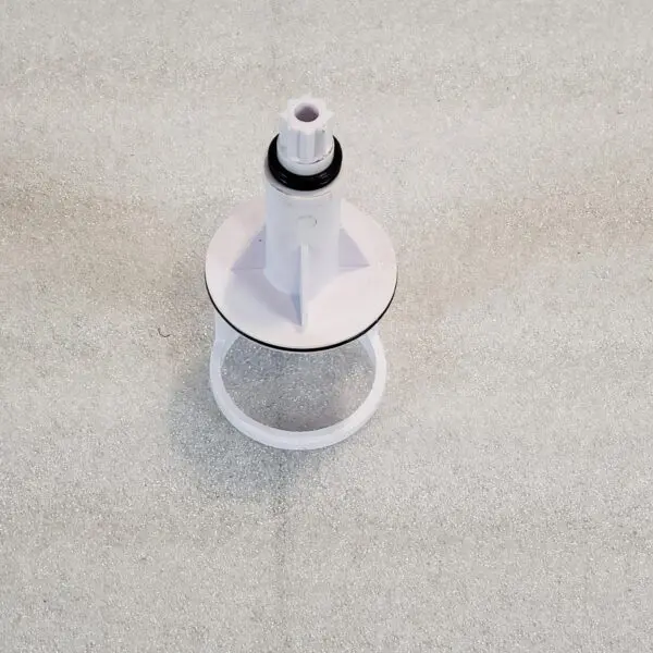 A white cone with a black top on the floor.