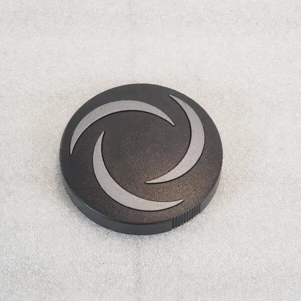 A black button with white design on it.