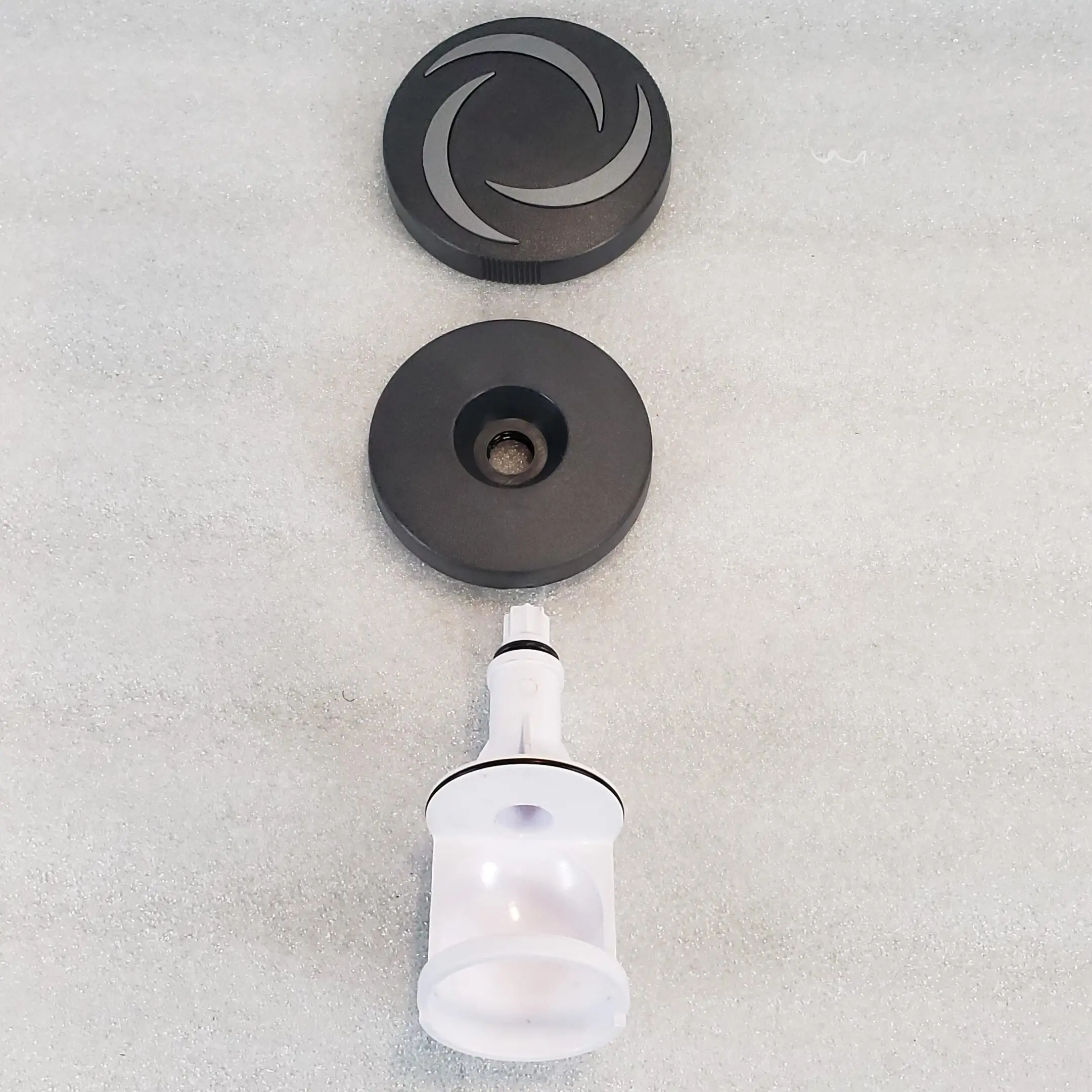A white and black water faucet with two black knobs.