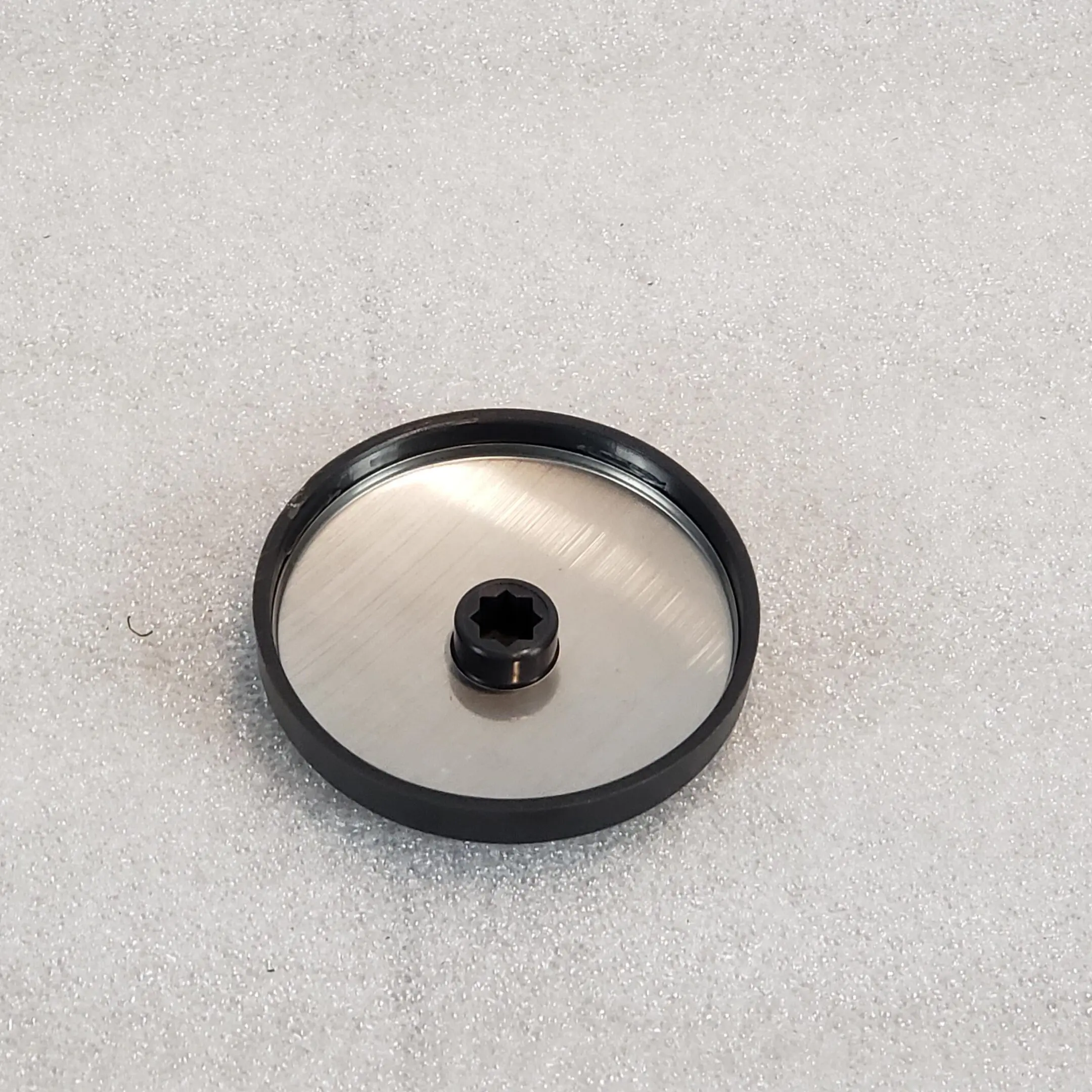 A black and silver object sitting on top of a white surface.