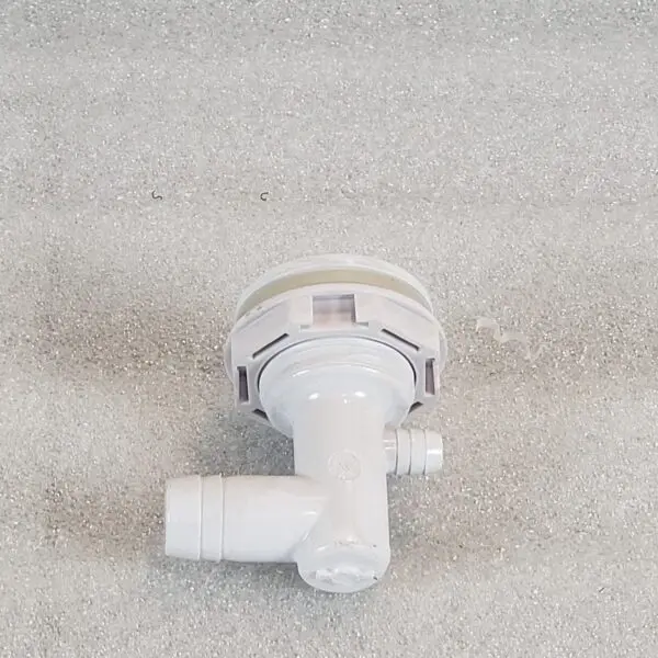 A white faucet sitting on top of a carpet.