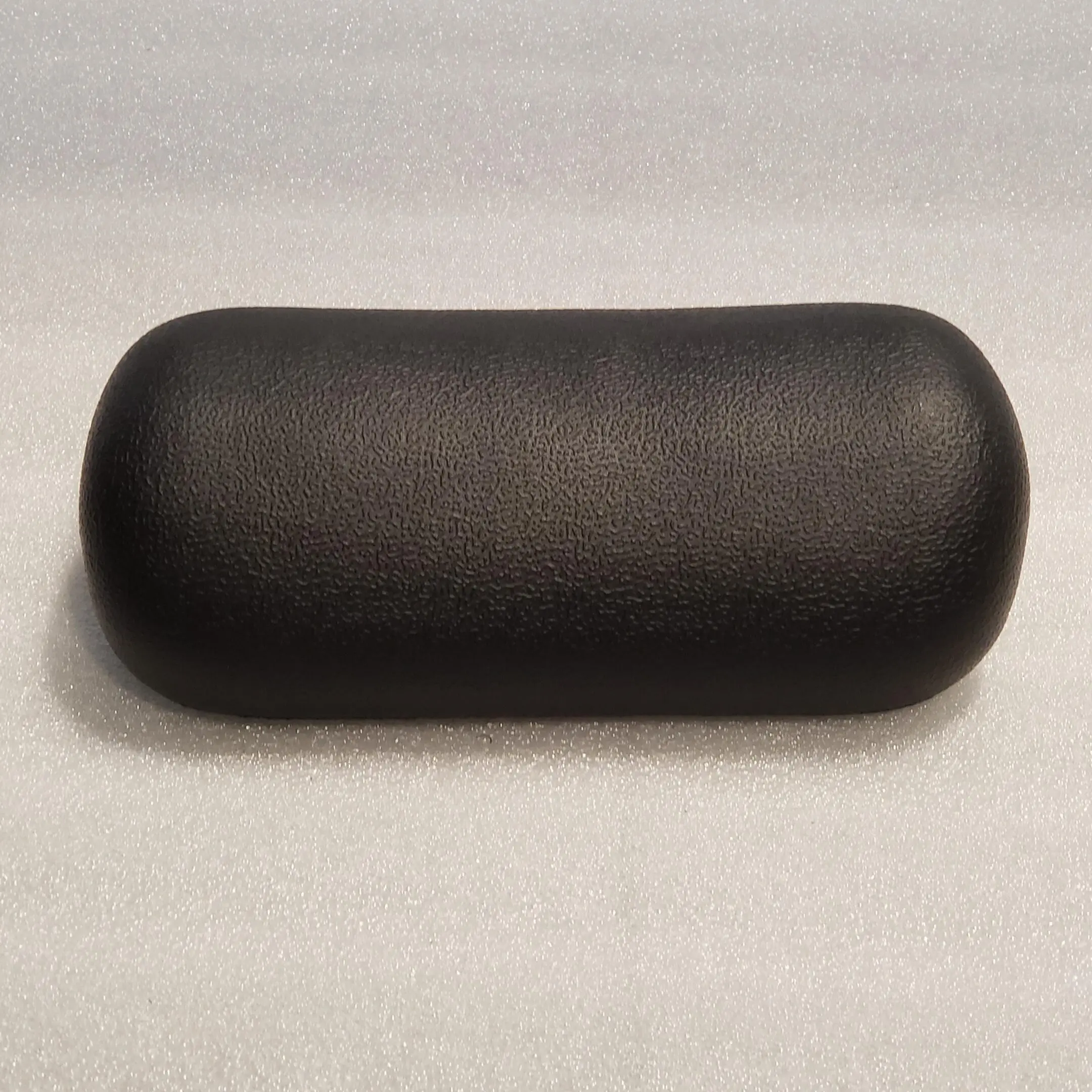 A black pillow sitting on top of a white table.