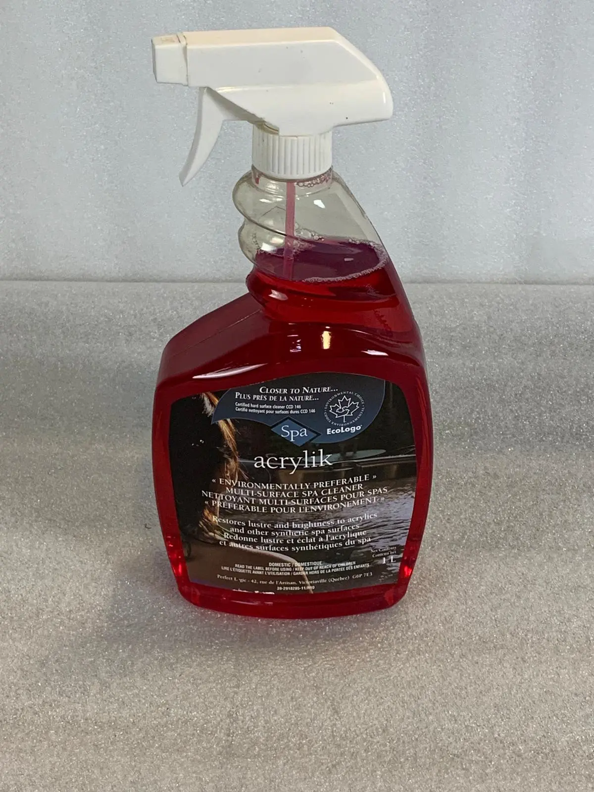 A red bottle of car wash soap sitting on top of a floor.