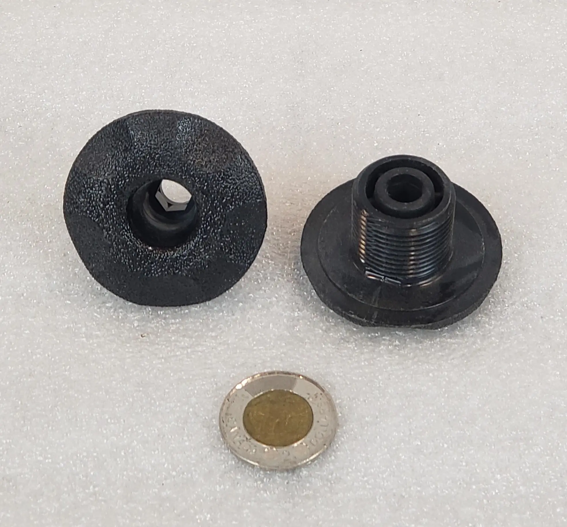 A black rubber washer and a metal washer.