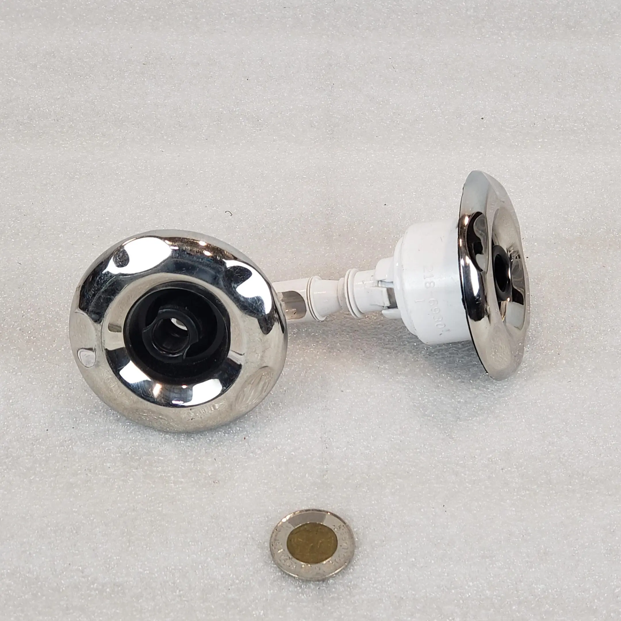 A pair of chrome knobs with a white knob.