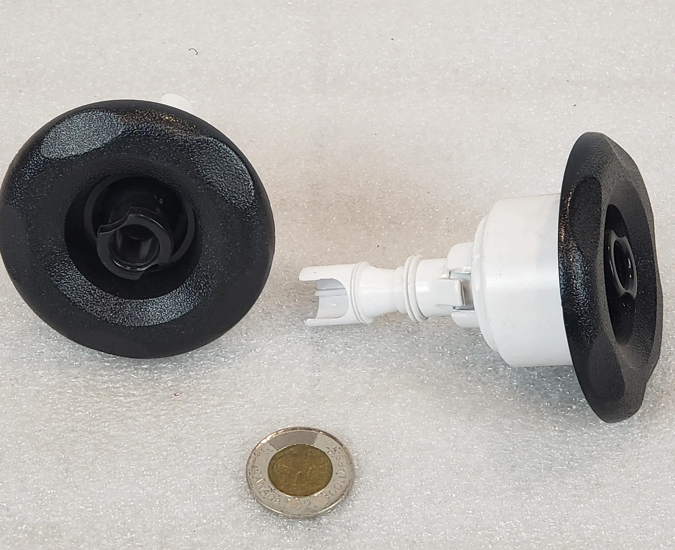 A black and white faucet with a penny