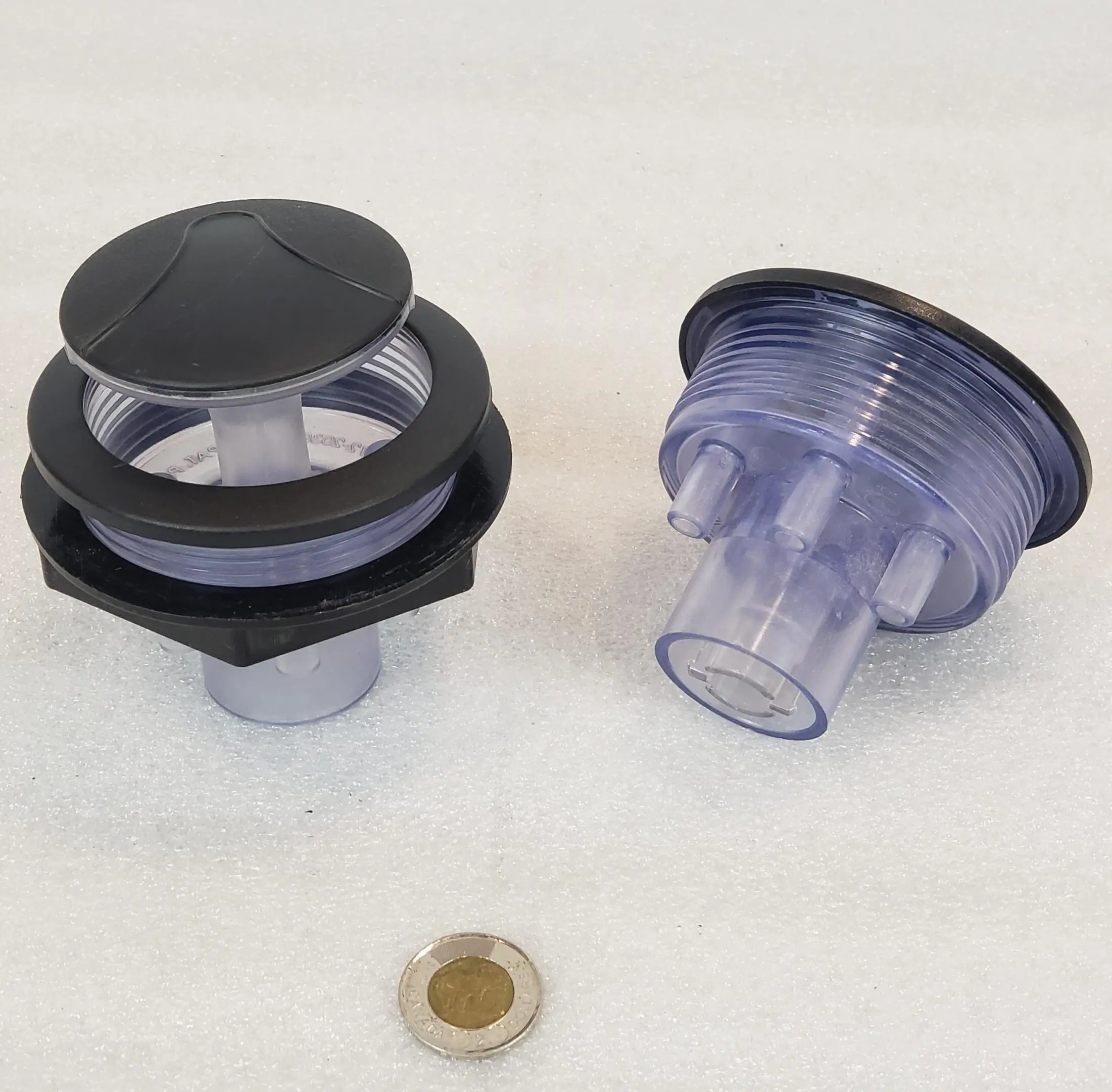 A couple of plastic parts that are next to a coin.