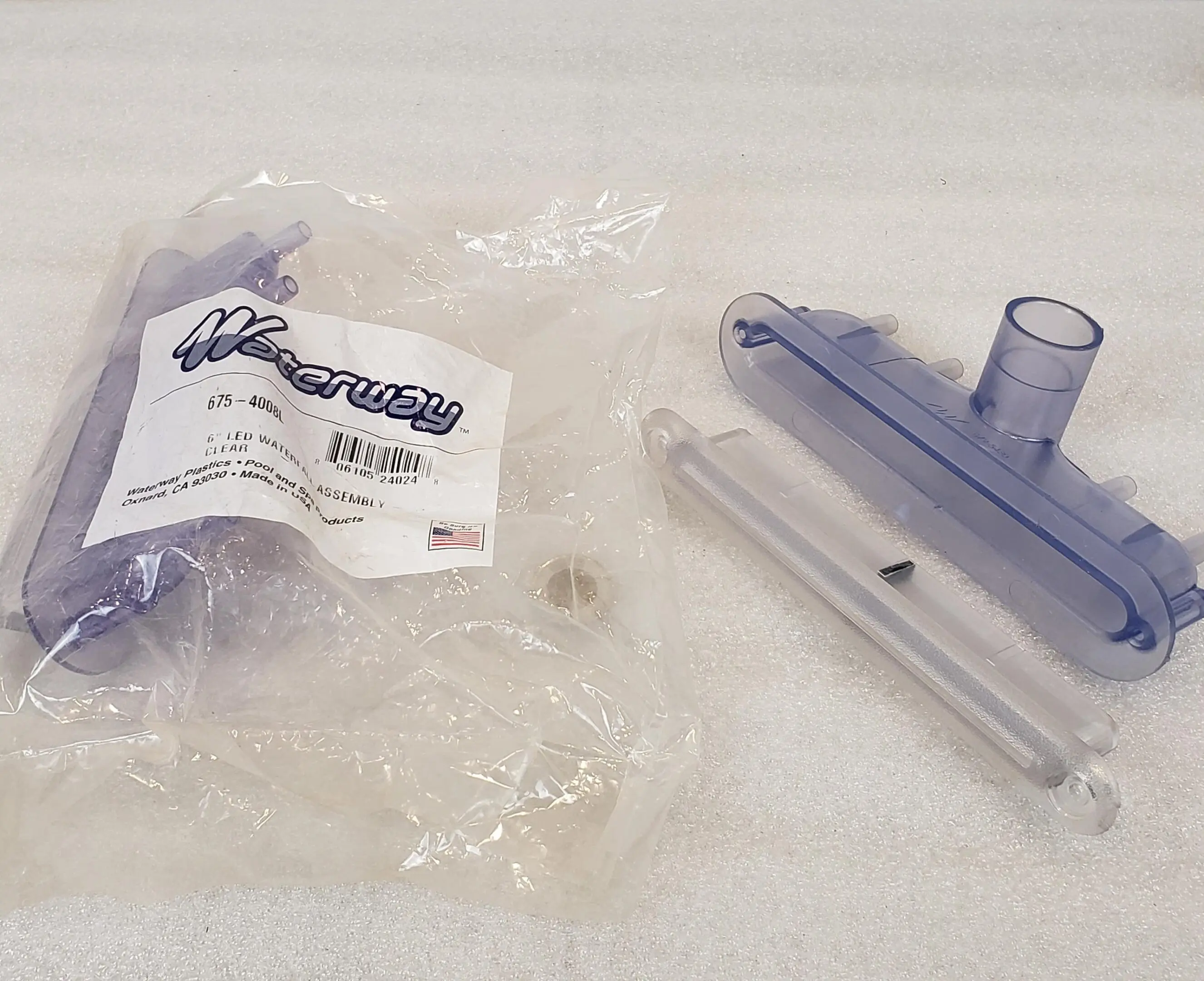 A plastic bag and some other items are laying on the floor.