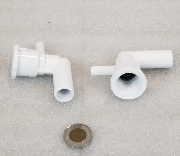 A pair of white plastic pipes and a metal nut.
