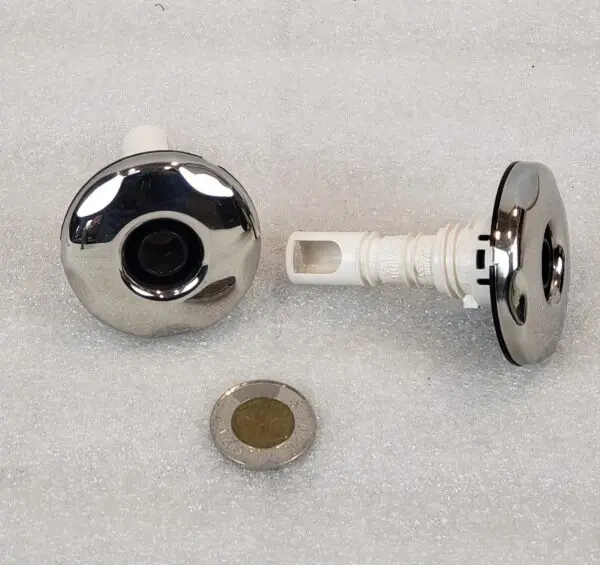 A pair of chrome knobs with a white handle.
