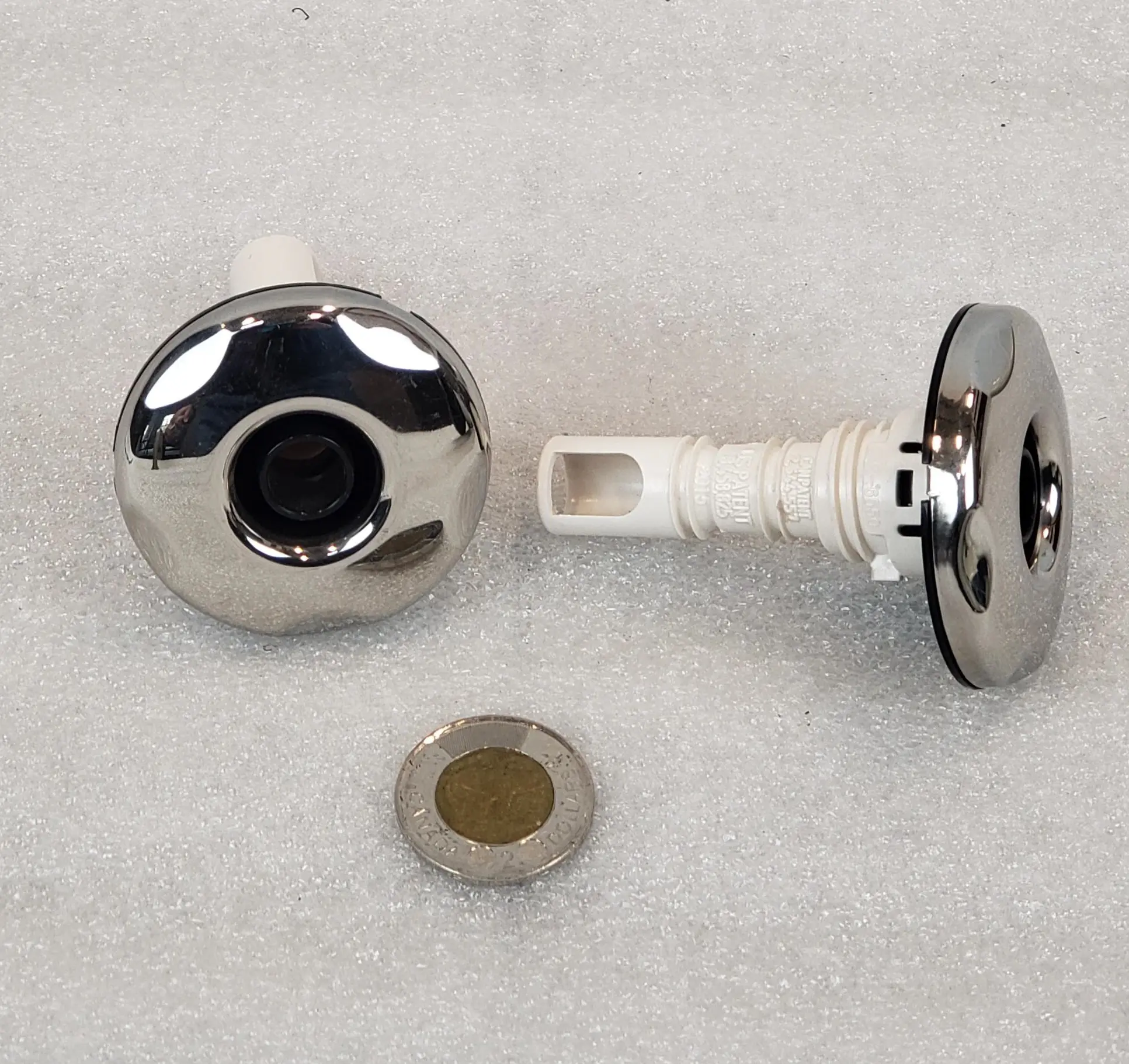 A pair of chrome knobs with a white handle.