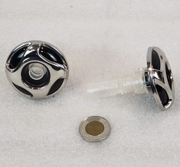 A black and white knob with a small hole in the center.