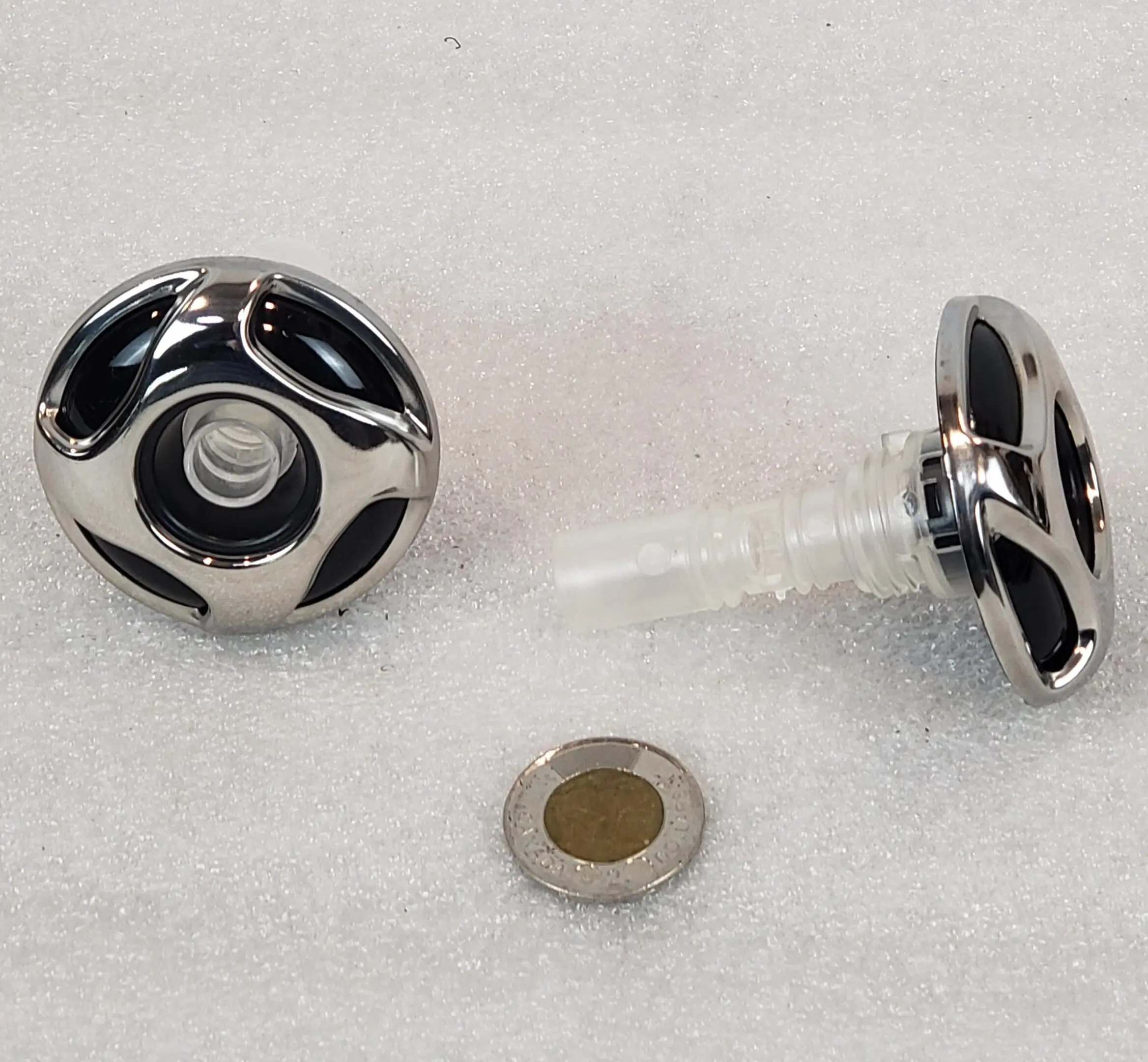 A black and white knob with a small hole in the center.