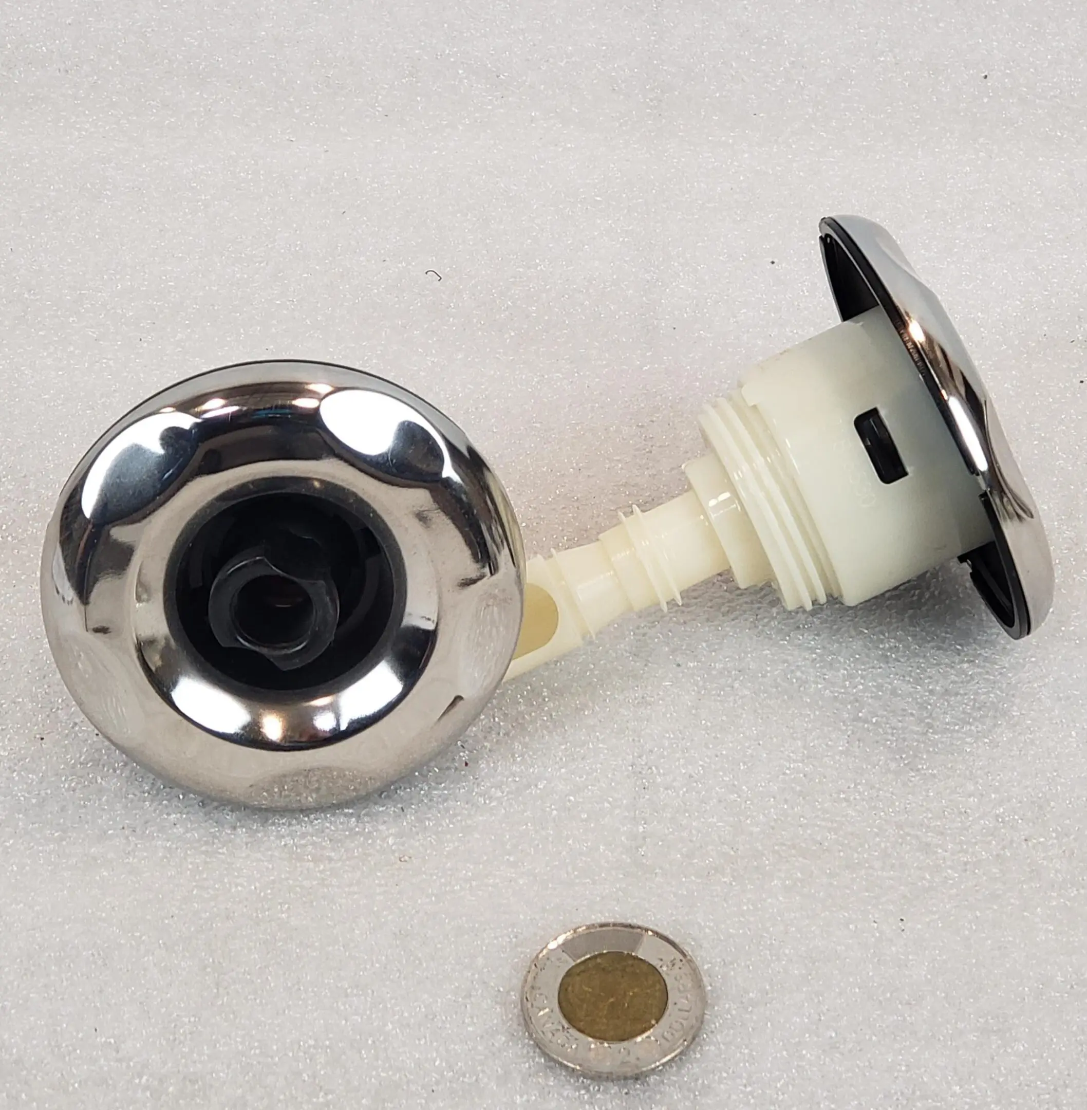 A metal knob with a small hole in the center.