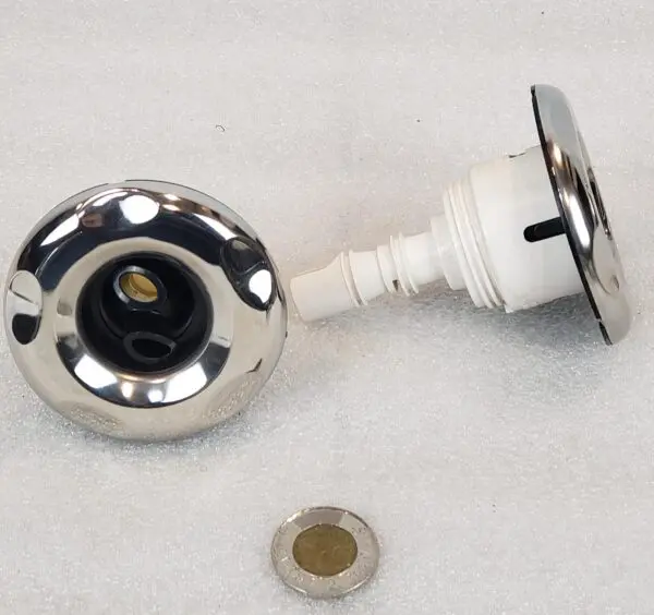 A chrome faucet with a white knob and a brown button.