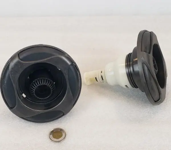 A black and white camera lens with a penny