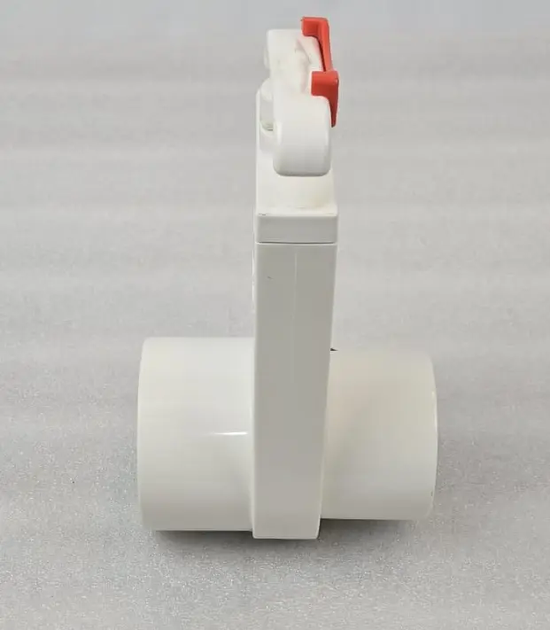 A white pipe with red handle on the floor.