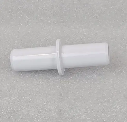 A white plastic tube with a hole in it.