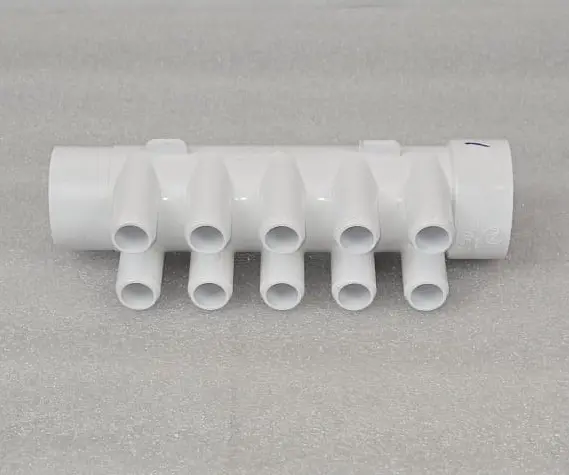 A white pipe with multiple pipes on top of it.