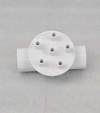 A white pipe with holes in it sitting on top of a table.