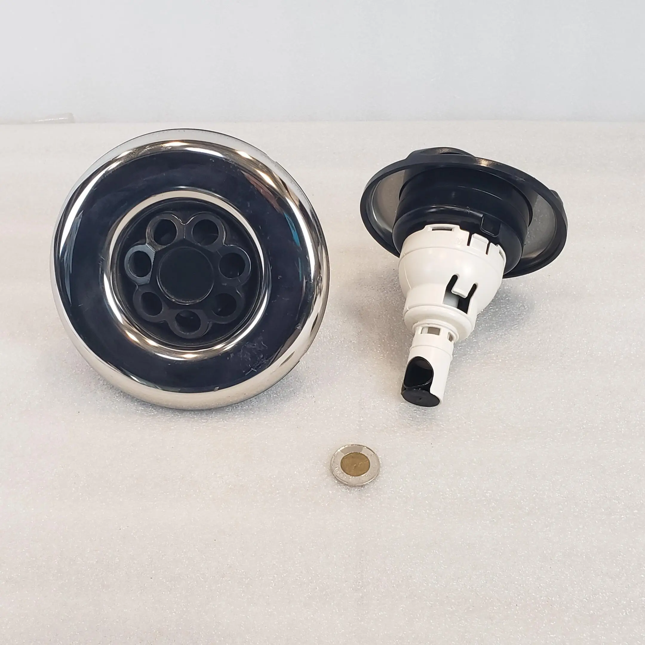 A black and white picture of a faucet with a brass disc.