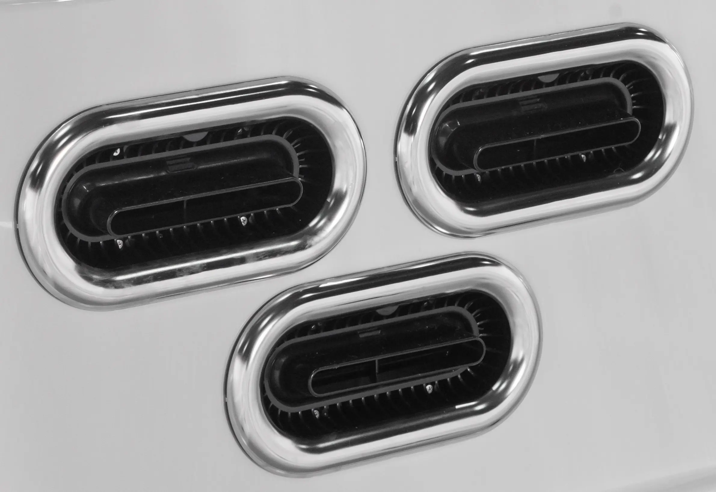 Three black and white photos of a toaster.