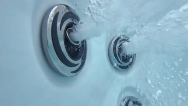 A close up of the water jets on the side of a bath tub.