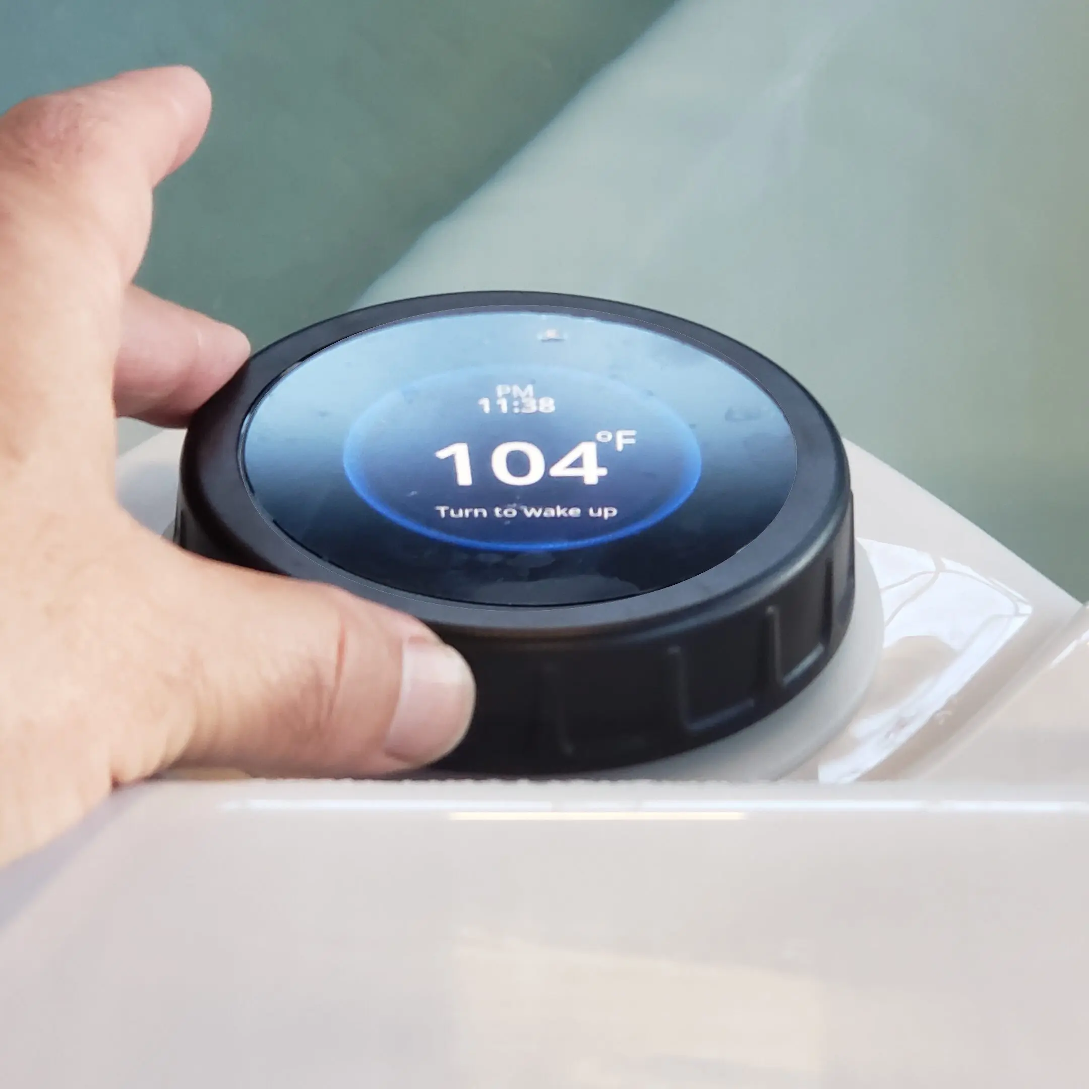 dil A hand is holding an electronic device with the time 1 0 4 degrees.