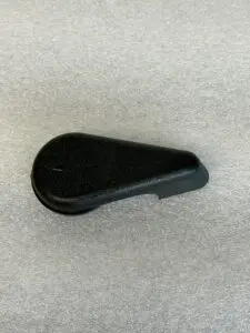 Black plastic lever on grey background.