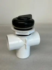 White plastic pipe with black knob.