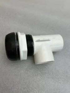 White plastic plumbing pipe fitting on surface.